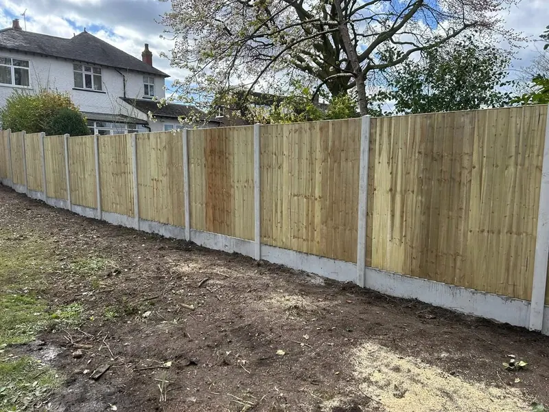 Long run of new timber fence panels set between concrete posts