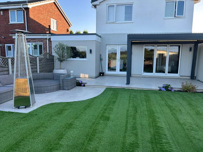 Contemporary garden with a covered pergola, porcelain paving and artificial lawn