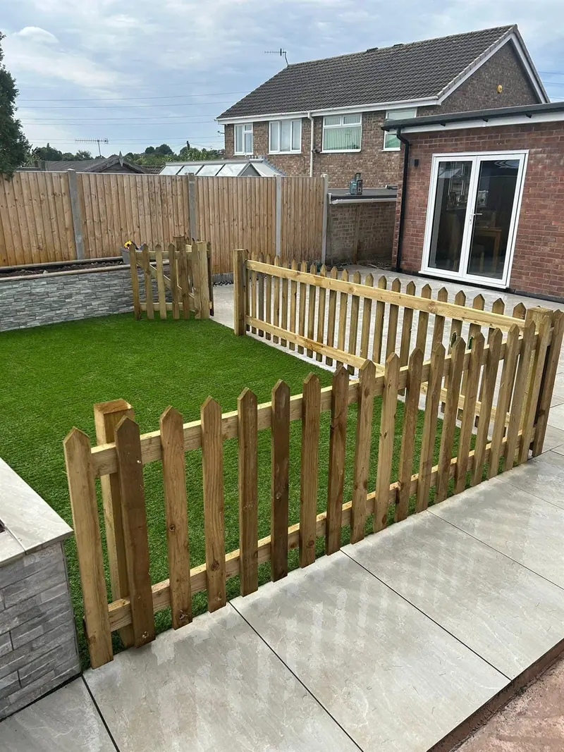 Timber picket fencing around an artificial lawn and porcelain-paved patio