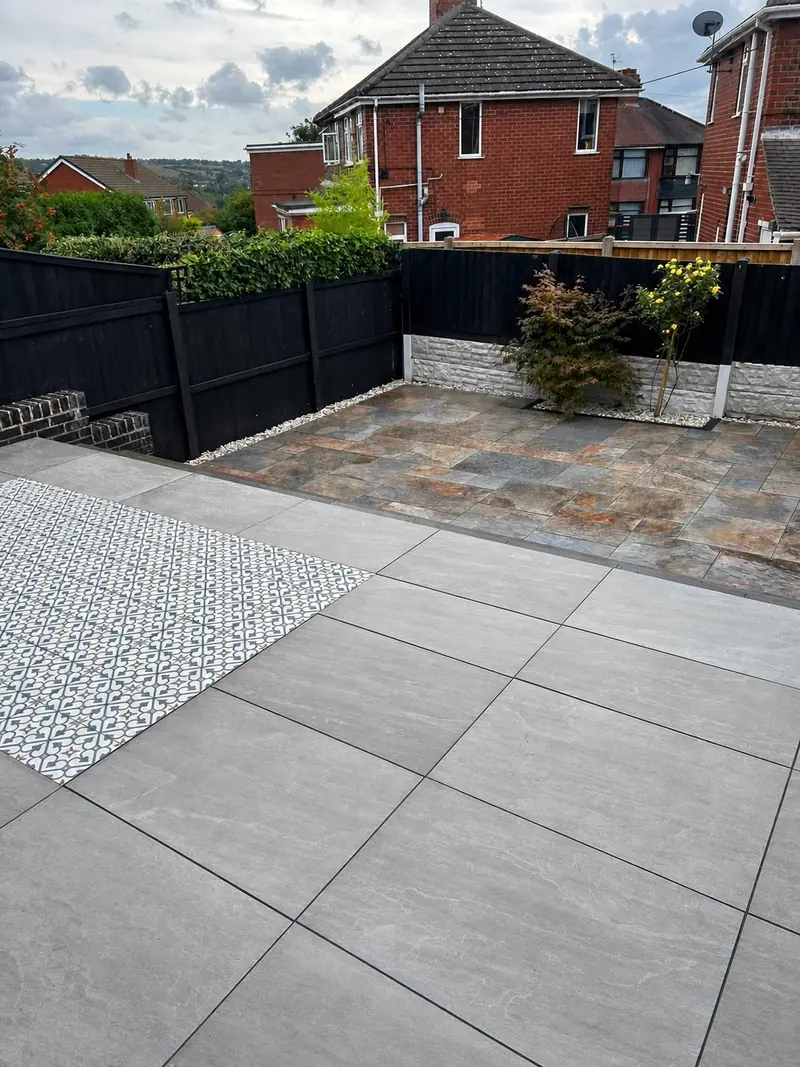 Contrasting paved patio areas with dark fencing and decorative aggregate