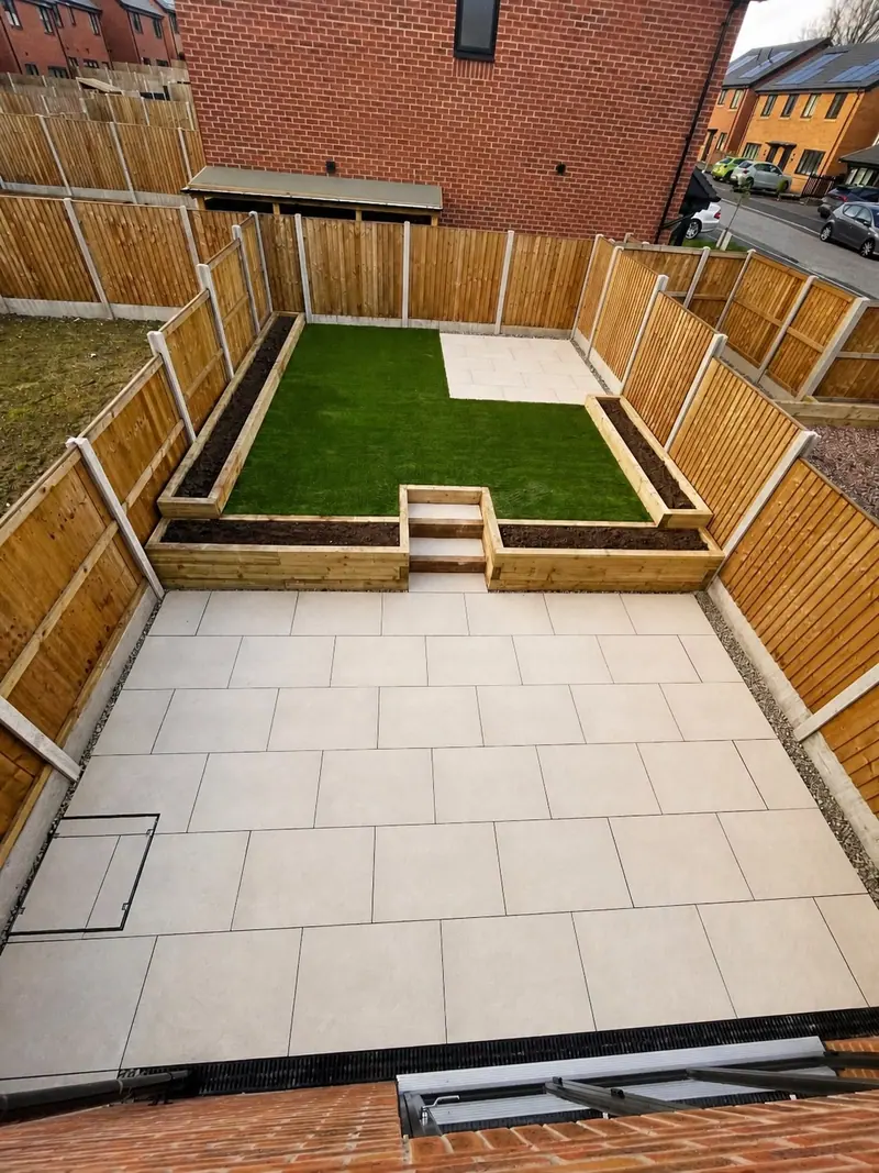 Paved patio, artificial lawn and raised sleeper planting beds