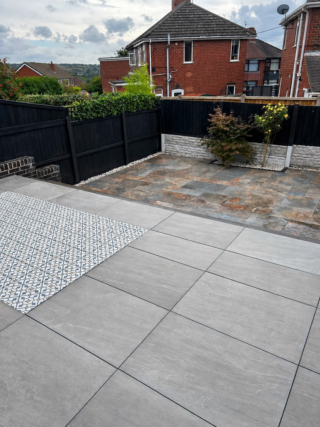 Large paved patio with fencing and decorative aggregate